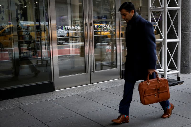 A man passes by E*Trade Financial offices, after it was announced that Morgan Stanley is buying the discount brokerage, in New York