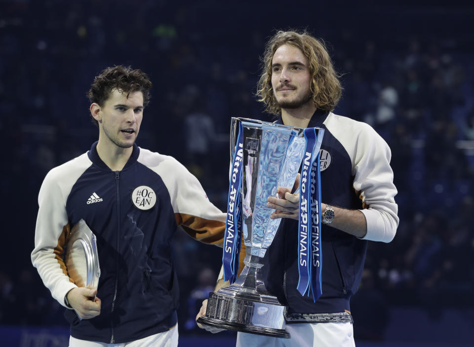 Stefanos Tsitsipas of Greece, right, and Austria's Dominic Thiem pose for the media with their trophies after the final of the ATP World Finals tennis match in which Tsitsipas defeated Thiem at the O2 arena in London, Sunday, Nov. 17, 2019. (AP Photo/Kirsty Wigglesworth)