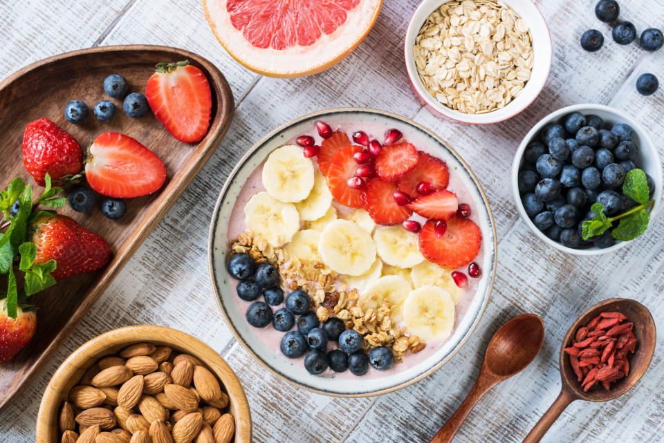 Smoothie bowl with banana slices, strawberry, blueberries, granola and pomegranate seeds. Top view. Healthy lifestyle, healthy eating, dieting, weight loss concept. (Getty Images)