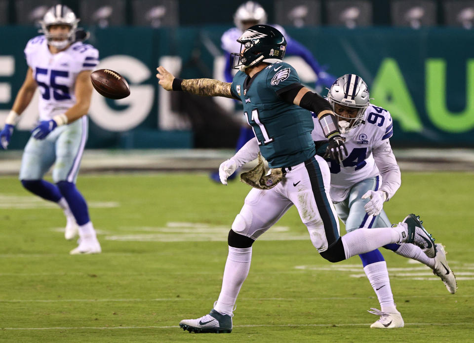Quarterback Carson Wentz #11 of the Philadelphia Eagles flicks an incomplete pass while under pressure from Randy Gregory #94 of the Dallas Cowboys in the third quarter of the game at Lincoln Financial Field on November 01, 2020 in Philadelphia, Pennsylvania. (Photo by Elsa/Getty Images)