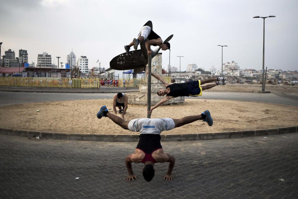 Palestinian group, Bar Palestine, take part in street exercises on a roundabout in Gaza City on August 3, 2015. Street workout, that is still new to Gaza, is a growing sport across the world with annual competitions and events.