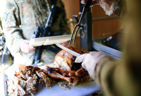 A U.S. soldier serves turkey to fellow soldiers to celebrate Thanksgiving Day inside the U.S. army base in Qayyara, south of Mosul, Iraq November 24, 2016. REUTERS/Thaier Al-Sudani