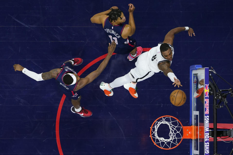 Brooklyn Nets' Lonnie Walker IV, right, goes up for a shot against Philadelphia 76ers' Jaden Springer, center, and Paul Reed during the first half of an NBA basketball game, Saturday, Feb. 3, 2024, in Philadelphia. (AP Photo/Matt Slocum)