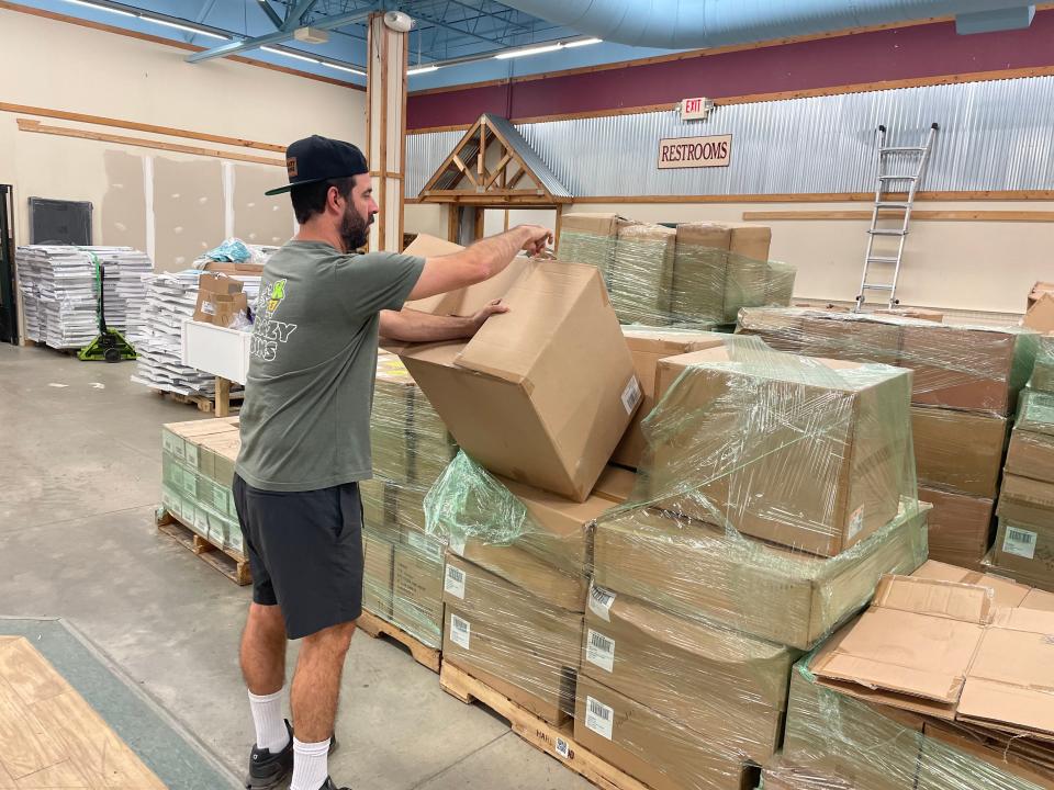 Krazy Racks owner Noah Leavitt opens a box of merchandise inside his new Twinsburg location in the Creekside Plaza off Darrow Road.
