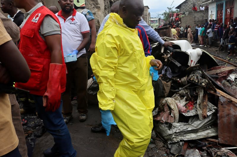 Civilians gather at the site where a Dornier 228-200 plane operated by local company Busy Bee crashed into a densely populated neighborhood in Goma