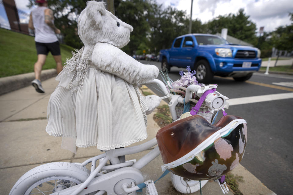 A vehicle drives past a memorial for 5-year-old Allie Hart, who was struck and killed in 2021 by a driver while riding her bicycle in a crosswalk, Monday, Sept. 11, 2023, in Washington. (AP Photo/Mark Schiefelbein)