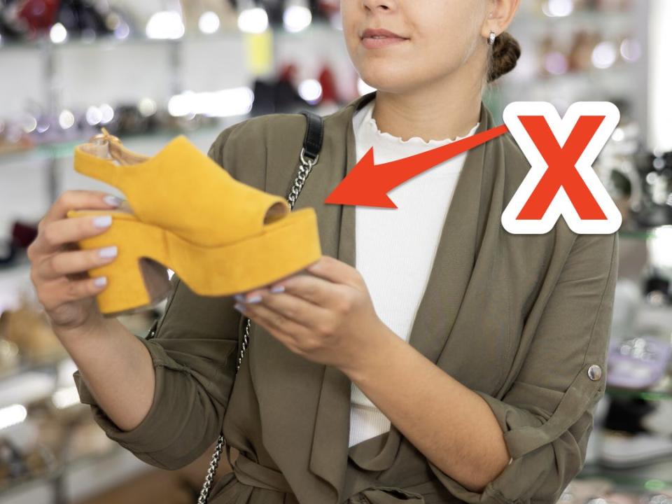 Woman holding peep-toe mule heel shoe in yellow.