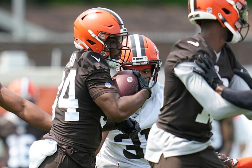 Cleveland Browns running back Jerome Ford, left, carries the ball during practice May 24 in Berea.