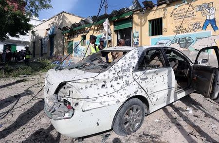 Somali police look at a wreckage of a car at the scene of an explosion near Waberi police station station in Mogadishu, Somalia June 22, 2017. REUTERS/Feisal Omar