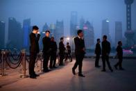 Security guards stand in front of a entrance of the Louis Vuitton fashion show in Shanghai, July 19, 2012.