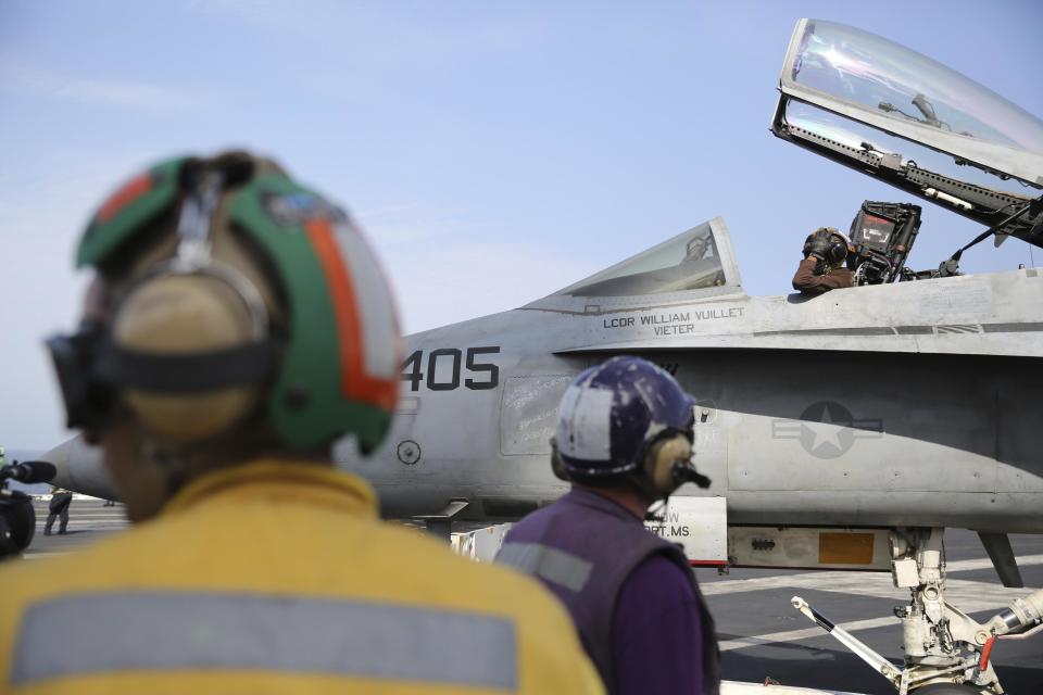 In this Monday, March 20, 2017 photograph, the pilot of an F-18 fighter jet prepares to take off from the USS George H.W. Bush as it travels toward the Strait of Hormuz. The arrival of the nuclear-powered aircraft carrier to the Persian Gulf marks the first such deployment under new U.S. President Donald Trump. (AP Photo/Jon Gambrell)