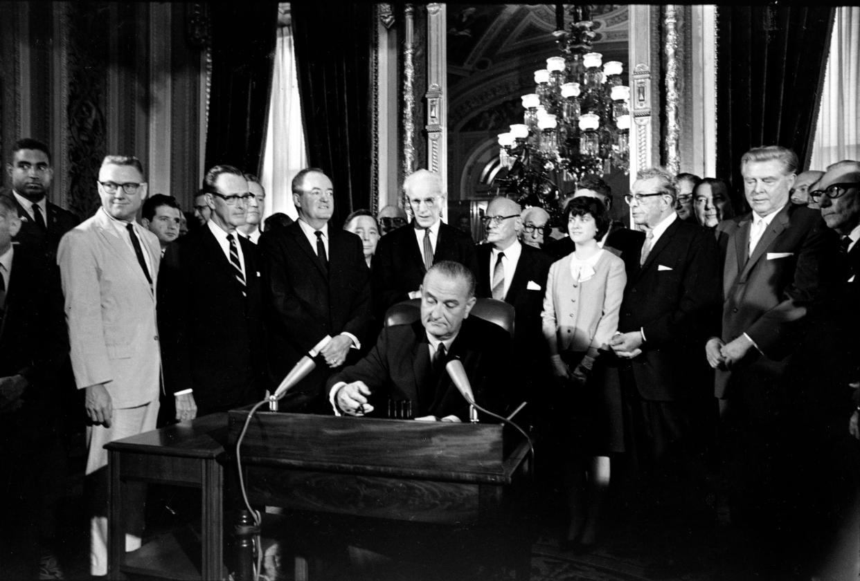 FILE - In this Aug. 6, 1965, photo, President Lyndon Baines Johnson signs the Voting Rights Act of 1965 in a ceremony in the President's Room near the Senate Chambers on Capitol Hill in Washington. 