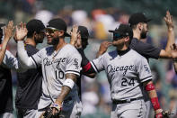 Chicago White Sox third baseman Yoan Moncada (10) and first baseman Yasmani Grandal (24) greet teammates after the ninth inning of a baseball game against the Detroit Tigers, Sunday, June 13, 2021, in Detroit. (AP Photo/Carlos Osorio)