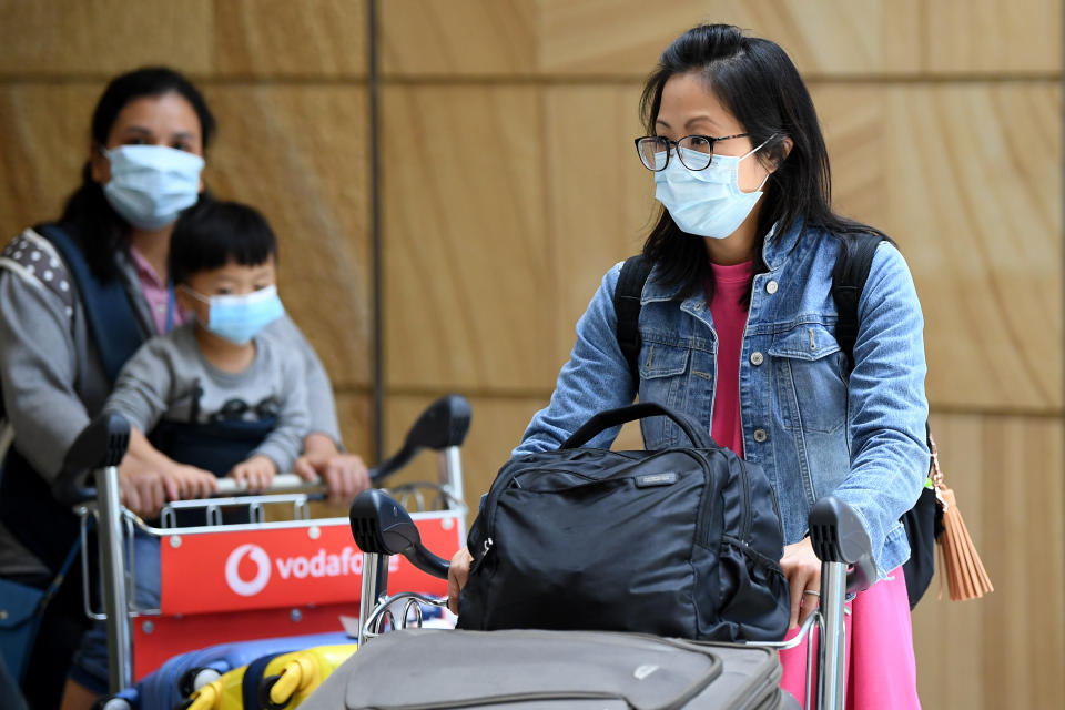 Passengers wearing protective masks arrive at Sydney International Airport in Sydney, Thursday, January 23. Source: AAP