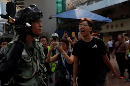 A man yells at riot police in Tsuen Wan, near the site where police shot a protester with live ammunition on China's National Day in Hong Kong