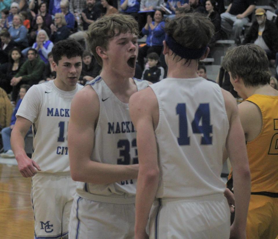 Mackinaw junior junior Trystan Swanson (33) celebrates with senior Lars Huffman (14) after Huffman made a basket and was fouled during the second quarter against Pellston on Wednesday.