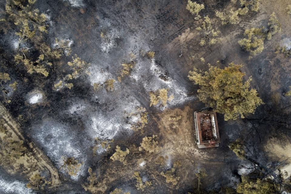 A burnt house at a forest in Agia Anna village on Evia island, about 181 kilometers (113 miles) north of Athens, Greece, Wednesday, Aug. 11, 2021. Hundreds of firefighters from across Europe and the Middle East worked alongside Greek colleagues in rugged terrain Wednesday to contain flareups of the huge wildfires that ravaged Greece's forests for a week, destroying homes and forcing evacuations. (AP Photo/Michael Varaklas)