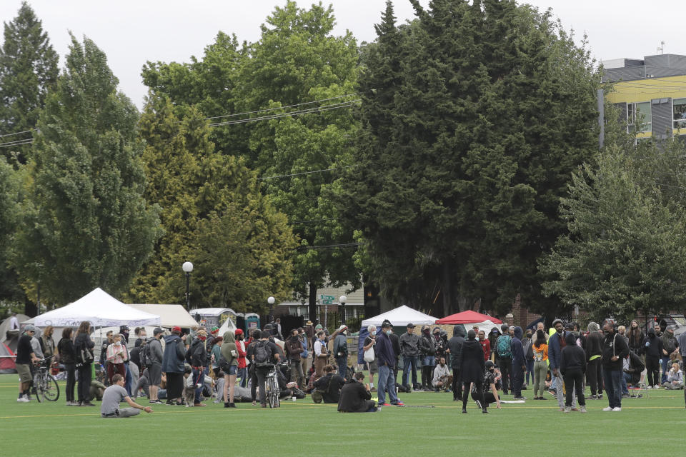 A meeting of protesters, organizers, and other is held, Saturday, June 20, 2020, in Cal Anderson Park in the Capitol Hill Occupied Protest zone in Seattle. A pre-dawn shooting near the area left one person dead and critically injured another person, authorities said Saturday. The area has been occupied by protesters after Seattle Police pulled back from several blocks of the city's Capitol Hill neighborhood near the Police Department's East Precinct building. (AP Photo/Ted S. Warren)