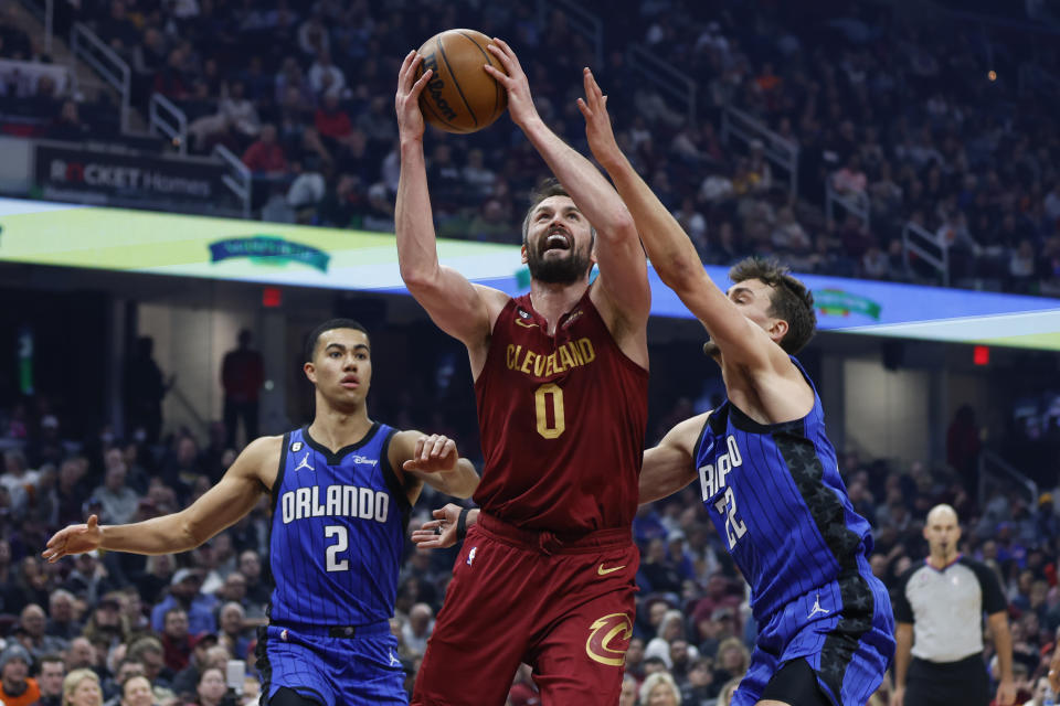 FILE - Cleveland Cavaliers forward Kevin Love (0) shoots against Orlando Magic forwards Franz Wagner (22) and Caleb Houstan (2) during the first half of an NBA basketball game Dec. 2, 2022, in Cleveland. Love, a five-time All-Star and 15-year NBA veteran, cleared waivers Monday, Feb. 20, 2023, then signed a contract to join the Miami Heat for the remainder of the season not long afterward. (AP Photo/Ron Schwane, File)