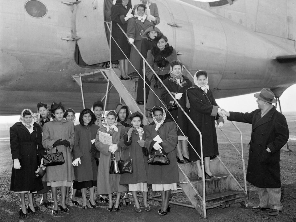 A group of Puerto Rican women, trained in household work by the Puerto Rican government, arrive at Newark Airport to work in homes in New York, 1953.