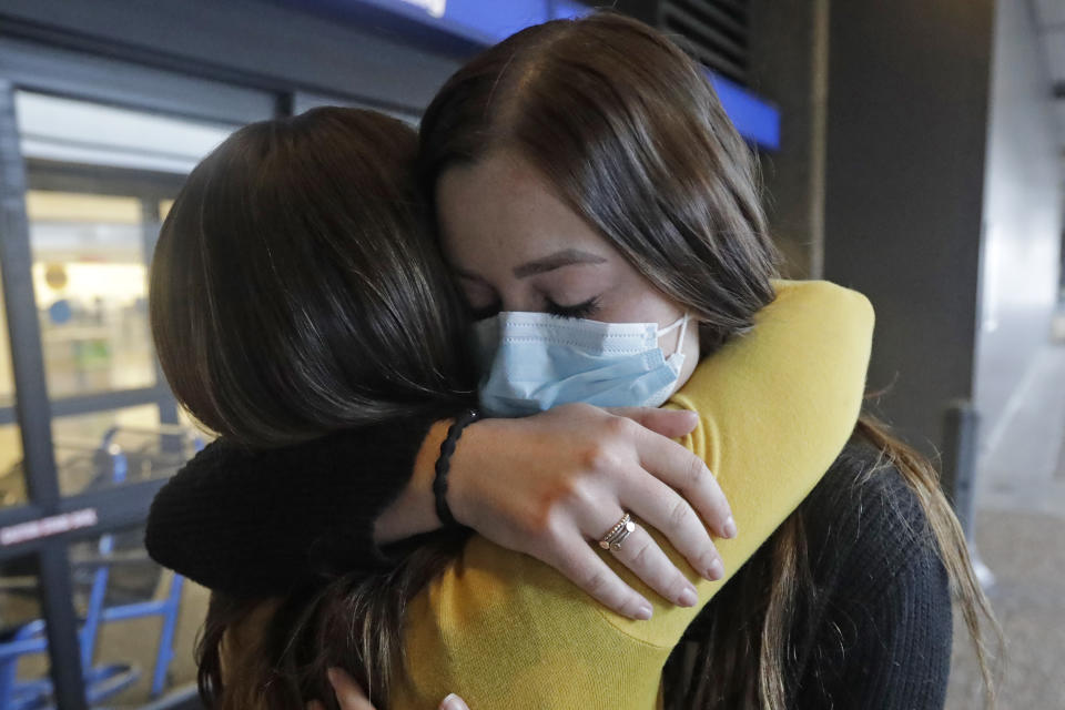 In this May 27, 2020, photo, Shaelee Palmer, 20, right, a missionary from The Church of Jesus Christ of Latter-day Saints, says goodbye to her mother Amber at Salt Lake City International Airport before leaving on her mission to North Carolina. After hastily bringing home 26,000 young men and women who were serving in foreign countries, the faith has begun sending many of them out again in their home countries with a new focus on online work that could stick even when the pandemic is over, church officials told The Associated Press. (AP Photo/Rick Bowmer)
