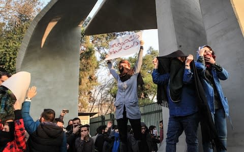 Iranian students protest at the University of Tehran during a demonstration driven by anger over economic problems, in the capital Tehran - Credit: AFP