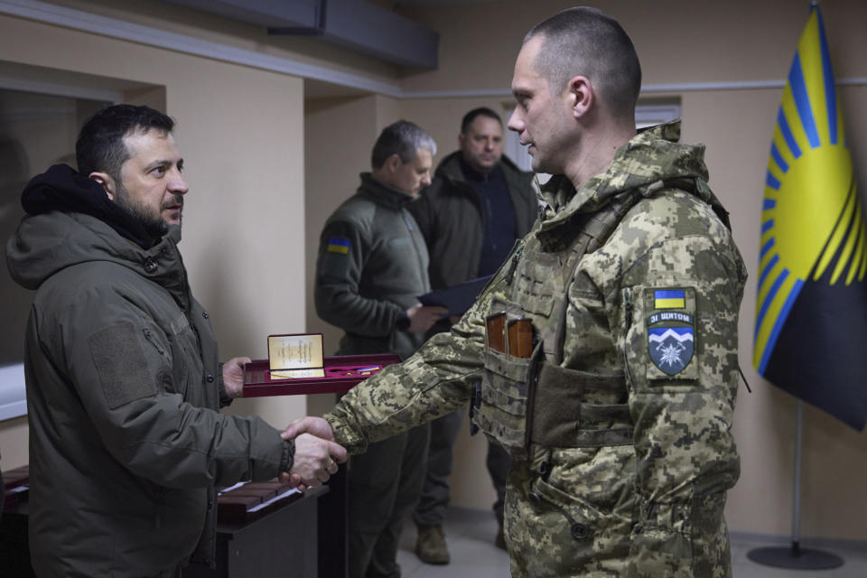 In this photo provided by the Ukrainian Presidential Press Office, Ukrainian President Volodymyr Zelenskyy, left, awards a serviceman during his visit to Sloviansk, Donbas region, Ukraine, Tuesday, Dec. 6, 2022. (Ukrainian Presidential Press Office via AP)