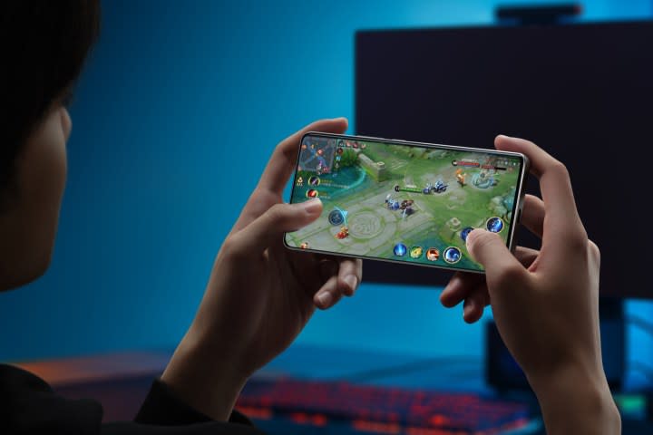 Person gaming on the Realme GT Neo 6 SE held in hands. 