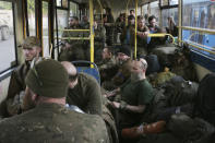 Ukrainian servicemen sit in a bus after they were evacuated from the besieged Mariupol's Azovstal steel plant, near a prison in Olyonivka, in territory under the government of the Donetsk People's Republic, eastern Ukraine, Tuesday, May 17, 2022. More than 260 fighters, some severely wounded, were pulled from a steel plant on Monday that is the last redoubt of Ukrainian fighters in the city and transported to two towns controlled by separatists, officials on both sides said. (AP Photo)