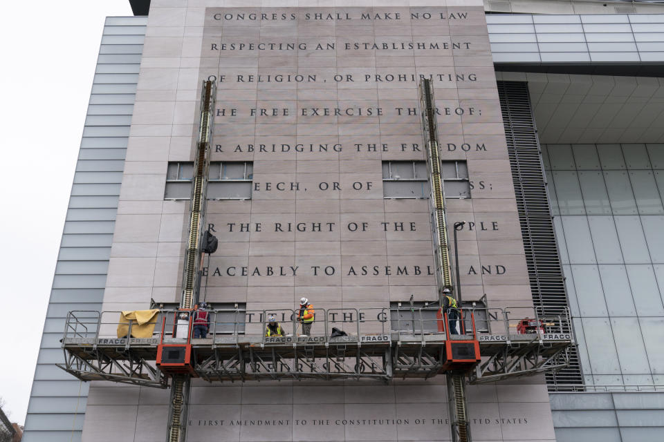 FILE—This file photo from Feb. 12, 2021, workers remove the facade bearing the First Amendment of the U.S. Constitution from what was formerly the Newseum, a private museum dedicated to exploring modern history as told through the eyes of journalists, along Pennsylvania Avenue, in Washington. The façade will be reinstalled at The National Constitution Center in Philadelphia. (AP Photo/Alex Brandon, File)