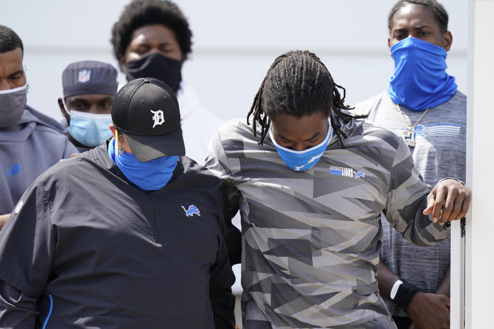 Matt Patricia, left, and Lions player listen with bowed heads during their statement to the media after canceling practice in August after the police shooting of Jacob Blake.