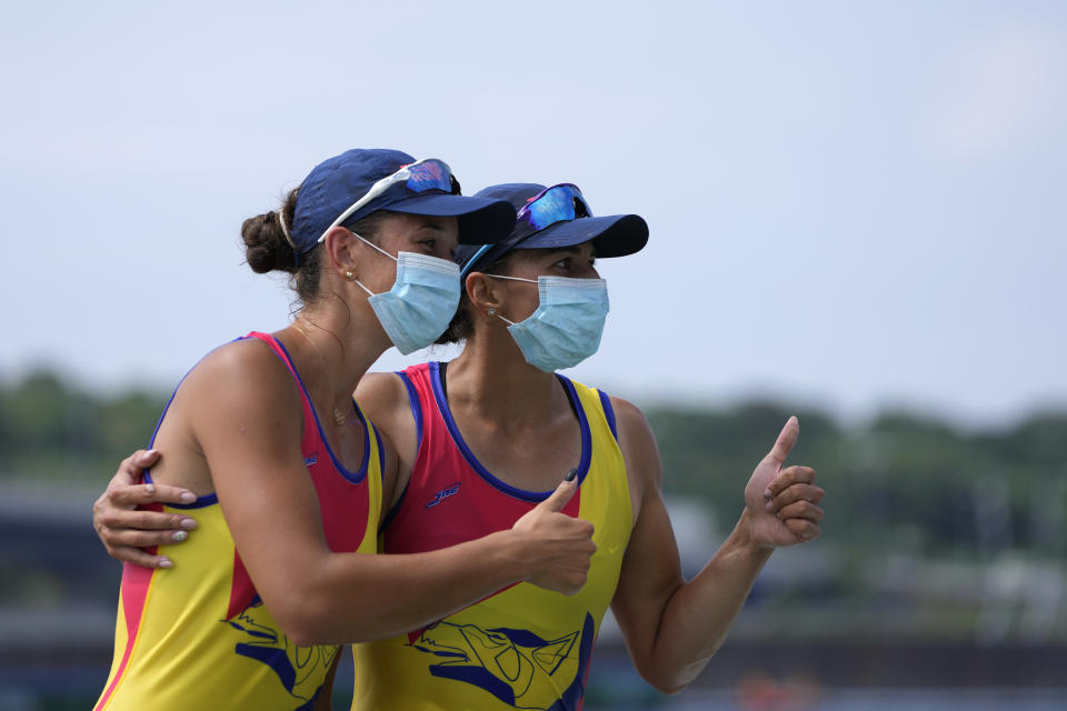 Gold medalists Ancuta Bodnar and Simona Radis of Romania pose for photographers after winning the women's rowing double sculls final at the 2020 Summer Olympics, Wednesday, July 28, 2021, in Tokyo, Japan. (AP Photo/Lee Jin-man)