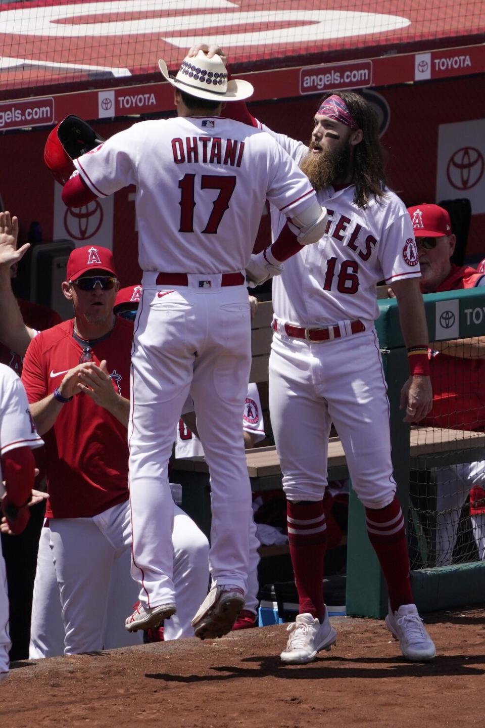 Brandon Marsh places the Angels' home run cowboy hat on Shohei Ohtani's head.