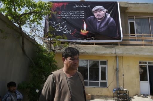 Ghulam Sakhi Allahdad, 38, stands under a poster bearing the image of his brother Wakil Hussain Allahdad, 32, one of the 57 victims of a suicide blast on a voter registration centre in Kabul, at Wakil's house in the city on April 23, 2018