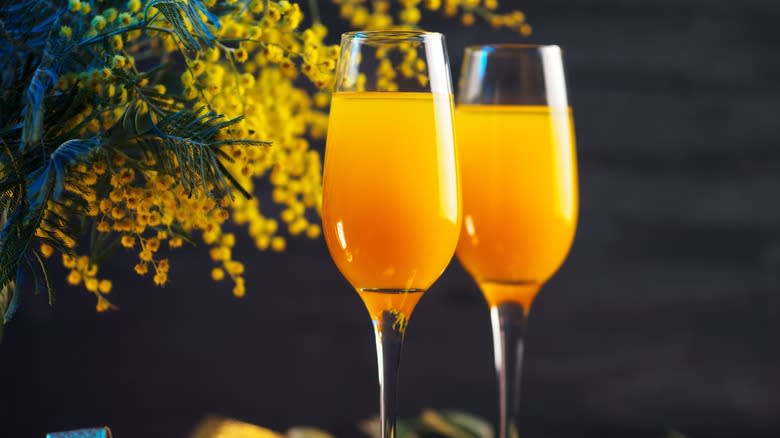 Two champagne flutes with mimosas