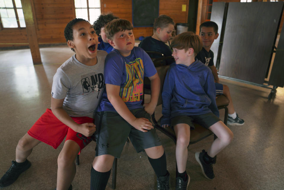 Campers of the YMCA Camp Kon-O-Kwee Spencer play a game of musical chairs on Thursday, June 29, 2023, in Zelienople, Pa. Due to the poor air quality caused by the Canadian wildfires the Western Pennsylvania summer camp closed its outdoor pool, transitioned to indoor activities and sent home a few campers with health problems. (AP Photo/Jessie Wardarski)