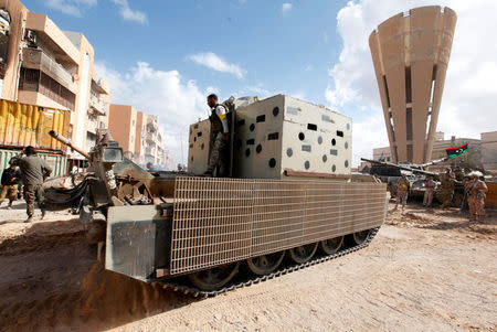 A fighter of Libyan forces allied with the U.N.-backed government stands on a military vehicle as forces advance against Islamic State holdouts in Ghiza Bahriya district in Sirte, Libya December 1, 2016. REUTERS/Ismail Zitouny