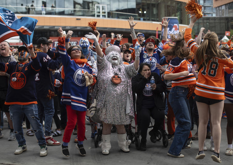 Edmonton Oilers fans celebrate a goal as they watch coverage of Game 5 of the NHL hockey Stanley Cup Final between the Oilers and the Florida Panthers on a large screen Tuesday, June 18, 2024, in Edmonton, Alberta. (Jason Franson/The Canadian Press via AP)