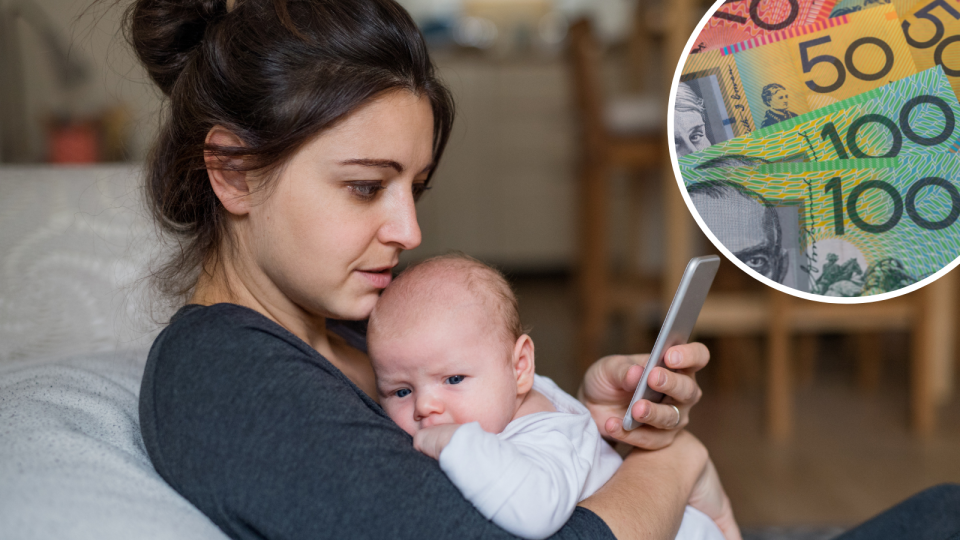 A new parent holds a baby while looking at a smart phone and Australian currency in the corner to signify paid leave.