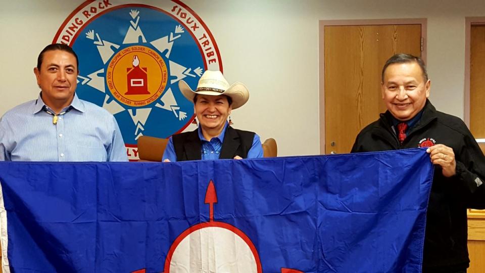 Grand Chief Stewart Phillip, right, and his wife Joan, centre, present the Union of B.C. Indian Chiefs flag to Standing Rock Sioux Tribal council chairman Dave Archambault II in September. Supplied photo.