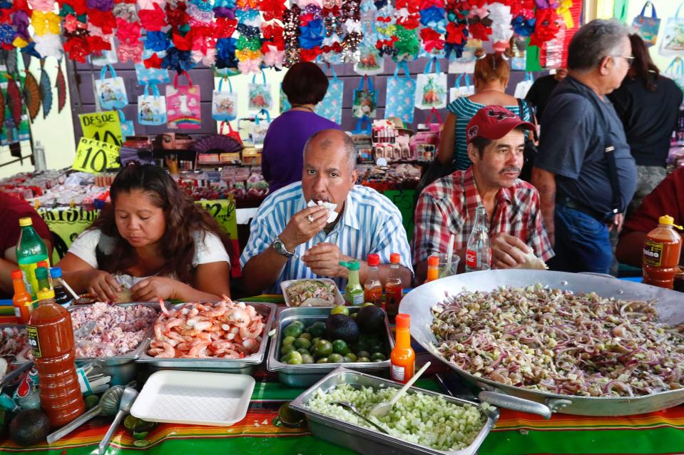 Clients eat at a street seafood stand despite measures taken in the city to avoid the spread of coronavirus on March 27.