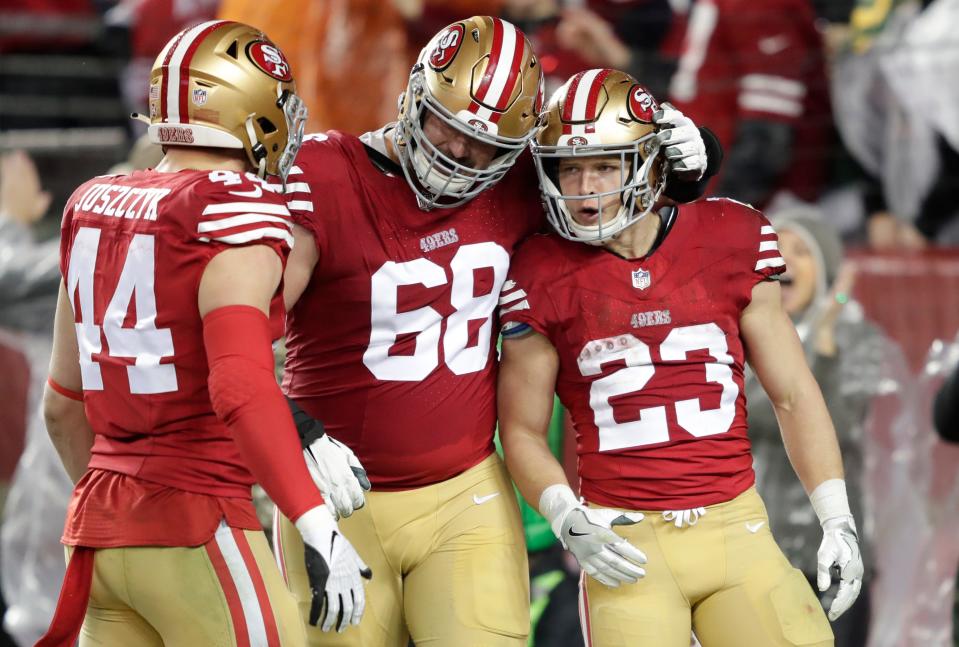 San Francisco 49ers running back Christian McCaffrey (23) celebrates scoring a touchdown in the third quarter with fullback Kyle Juszczyk (44) and offensive tackle Colton McKivitz (68) against the Green Bay Packers in a 2024 NFC divisional round game at Levi's Stadium.