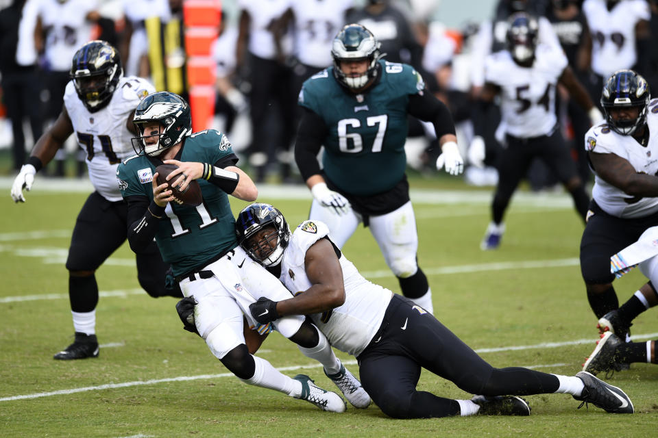 Philadelphia Eagles' Carson Wentz (11) is tackled by Baltimore Ravens' Calais Campbell (93) during the second half of an NFL football game, Sunday, Oct. 18, 2020, in Philadelphia. (AP Photo/Derik Hamilton)