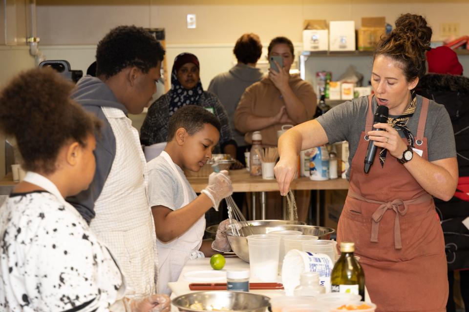 Food center director Caitlin Cullen, center, leads a cooking demonstration at Kinship Community Food Center in Milwaukee's Riverwest neighborhood.