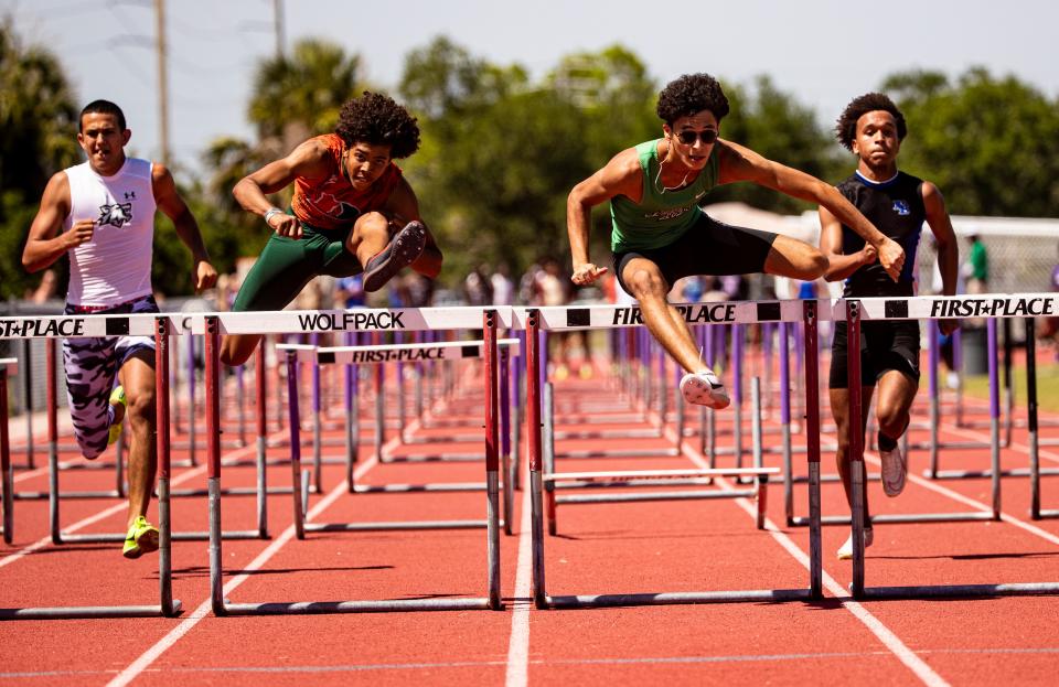 Thiago Lopes, center right, of Fort Myers and Kobe Johnson, center left, lead the boys 110 hurdles during the LCAC Track and Field Championships at Cypress Lake High School on Wednesday, April 17, 2024. Lopes won.