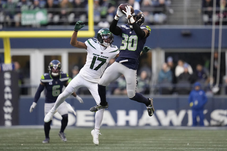Seattle Seahawks cornerback Mike Jackson (30) intercepts a pass intended for New York Jets wide receiver Garrett Wilson (17) during the second half of an NFL football game, Sunday, Jan. 1, 2023, in Seattle. (AP Photo/Godofredo A. Vásquez)