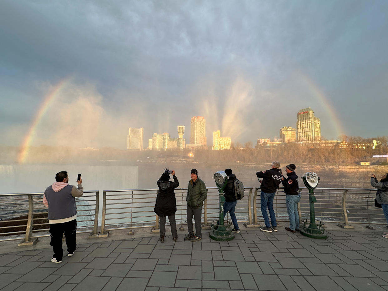 People at Niagara Falls State Park watch Niagara Falls and the rainbow ahead of a solar eclipse to take place later in the day, in Niagara Falls, N.Y. 