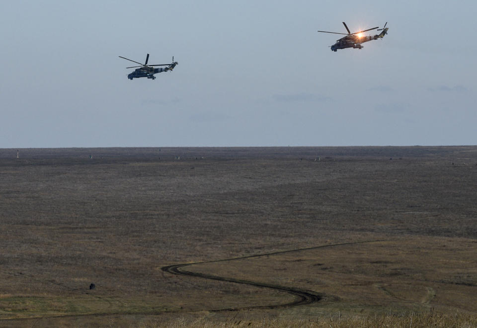 Ukrainian military helicopters fly during military exercise near Urzuf, south coast of Azov sea, eastern Ukraine, Thursday, Nov. 29, 2018. Ukraine put its military forces on high combat alert and announced martial law this week after Russian border guards fired on and seized three Ukrainian ships in the Black Sea. (AP Photo/Evgeniy Maloletka)