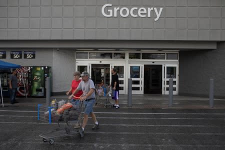 Shoppers walk out a Walmart store ahead of the arrival of Hurricane Dorian in Titusville