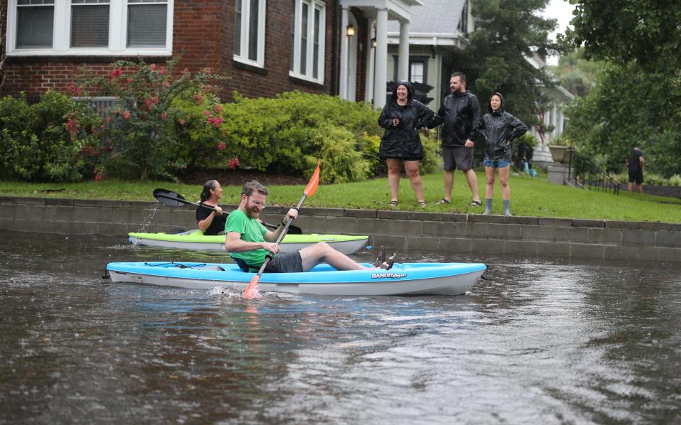 Ardsley Park residents watch as a pair of kayakers paddle around a flooded Habersham Street between 48th and 49th Streets on Monday, July 22, 2024.